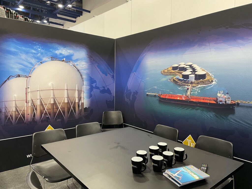 Tarsco exhibit meeting space with a display screen and black seating at Gastech.